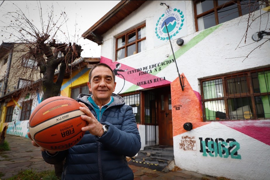 Frente edificio. Persona con pelota de básquet.
